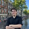 Student Phineas standing in front of a river in urban area