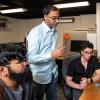 professor and 2 students talking in front of computer screen