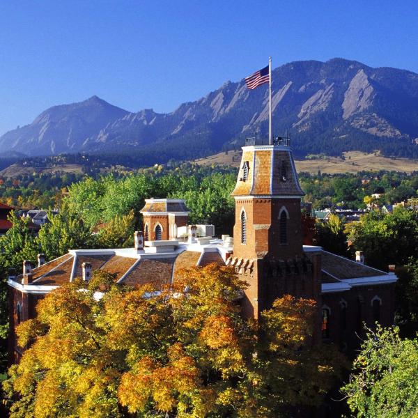 Old Main on a sunny day with the Flatirons in the background