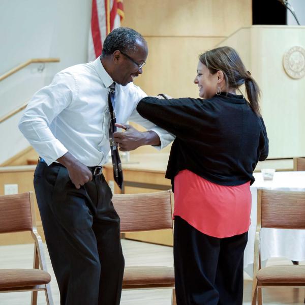 A man and woman lock arms and dance during the 2016 Diversity Summit
