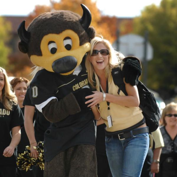 Chip the mascot with students during Family Weekend. Another use of backlighting to create a pleasing halo effect on subjects. A telephoto lens puts the background out of focus while still allowing the color on the foliage to add to the image.