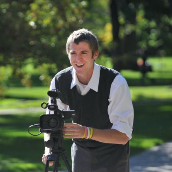 A journalism student works on a video. On sunny and contrasty days, it’s best to keep subjects with their backs to the sun. The rim of light on the subject is pleasing, and they are not squinting into the light.