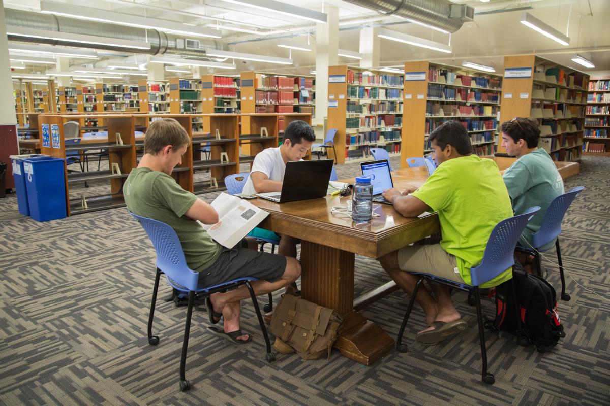 students studying at a table in library