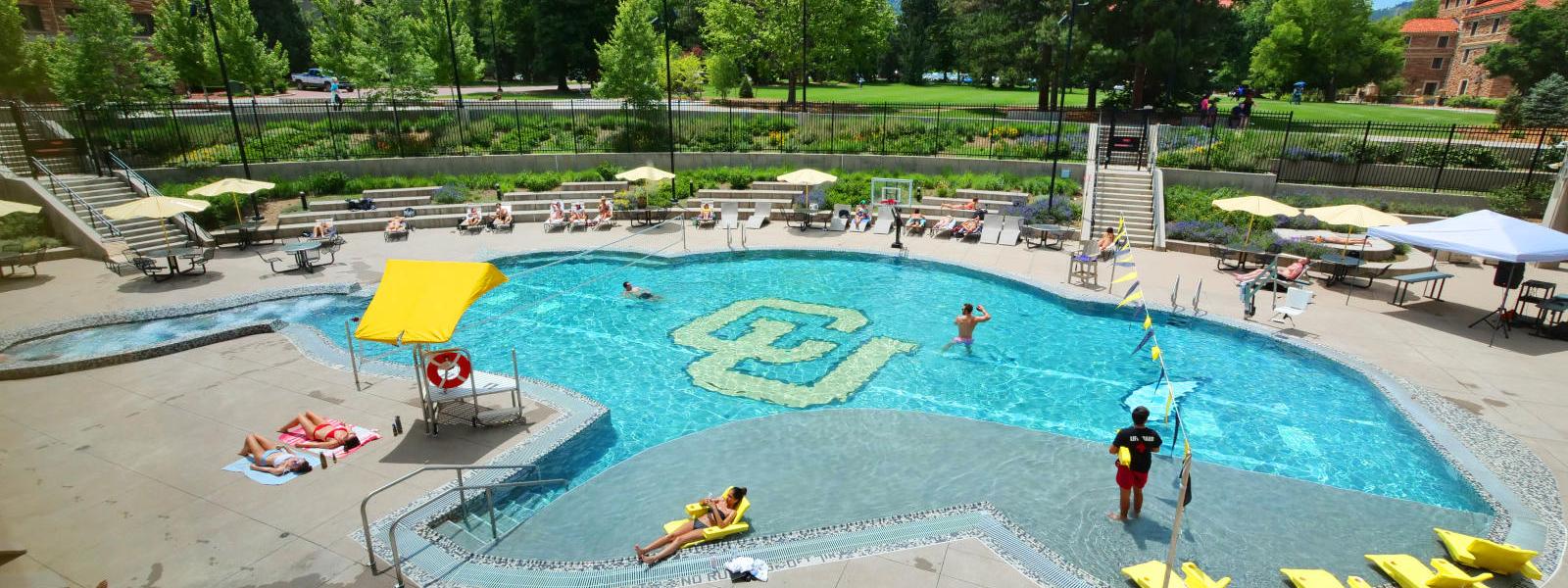 Students lounge around CU's buffalo shaped pool.