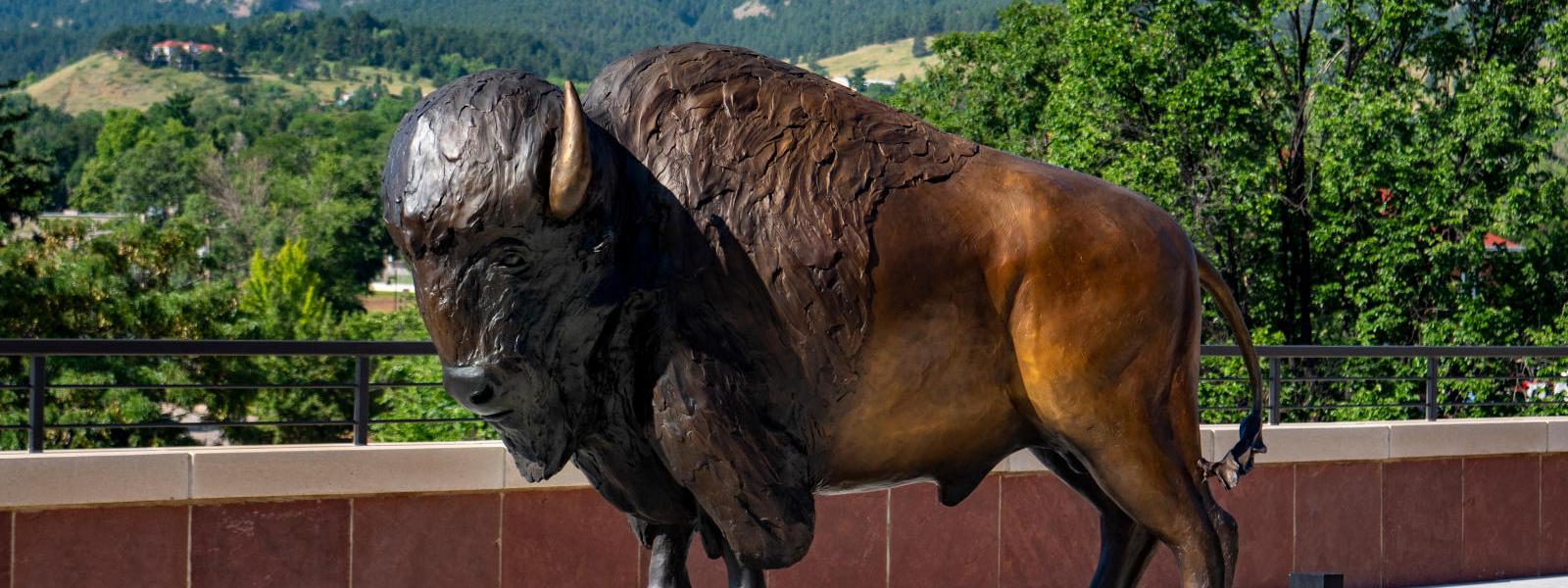 Ralphie statue in front of mountain scape.