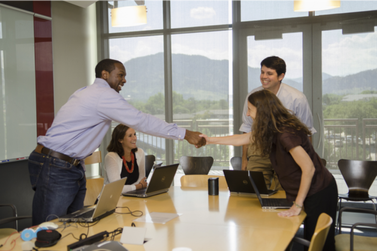 Group of students around a boardroom