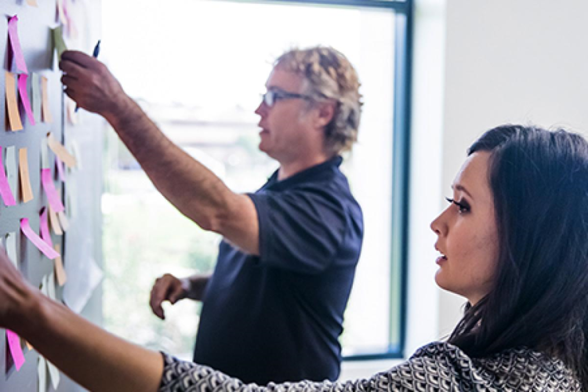 Undergraduate students moving post-it notes for operations management