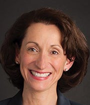 Headshot of Ellen against a dark background.