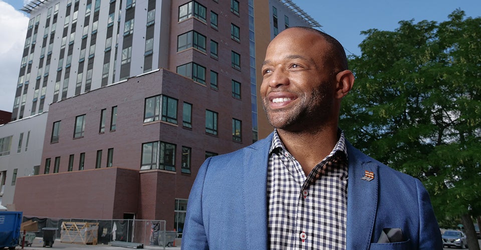 Albus Brooks smiles outside a construction site in Denver.