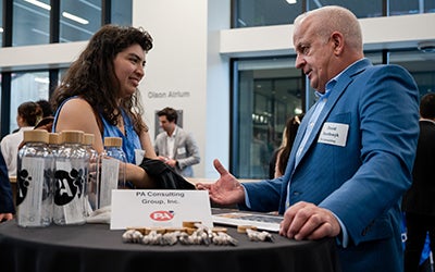 A hiring manager answers a female student's question at an industry chat.