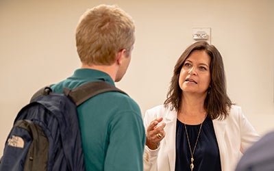 A female leader speaks one-on-one with a male student following a Q&A session.