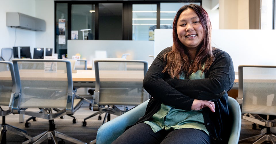 Christina sits with her arms folded in the Deming Center for Entrepreneurship offices.