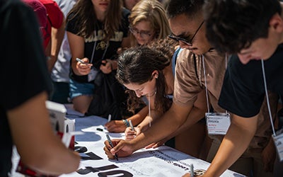 Students sign the Class of 2026 banner at Leeds Launch.