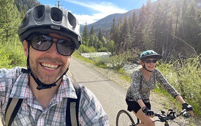 Court Rye takes a selfie on his bicycle. Another cyclist is visible in the foreground.