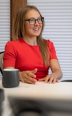 Colette Crouse talks at a conference table.