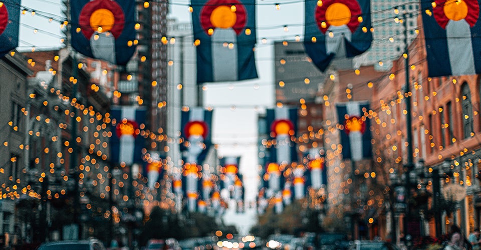 Larimer Square in Denver, with Colorado state flags flying in the background.