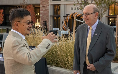 Two men stand outside the Rustandy Building.