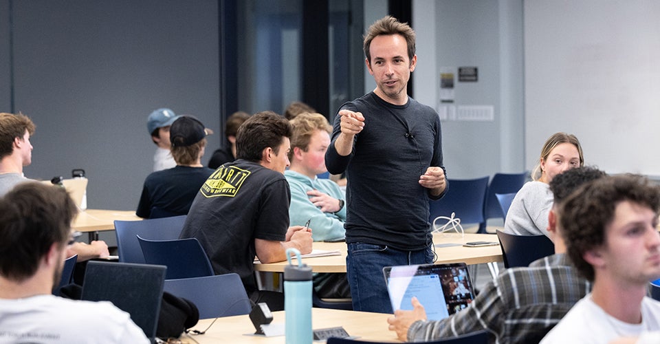 Mike DelPrete leads a classroom discussion in casual dress.