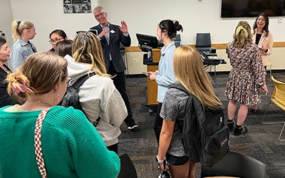 A crowd of students comes up to Clark Jones and Connie McCallon after the talk.