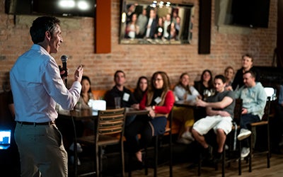 David Drake, seen from behind, as he leads a talk in a packed bar in downtown Boulder.