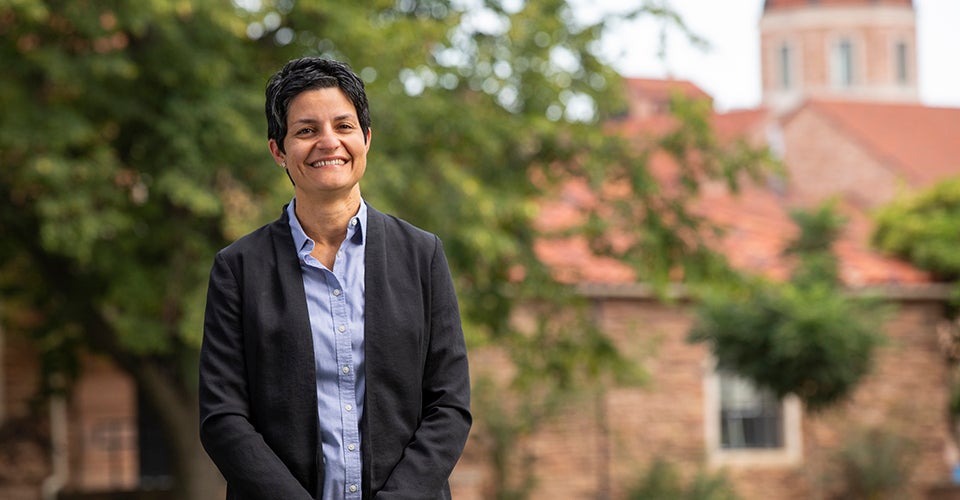 Yonca Ertimur poses outside of the Koelbel Building in professional attire.