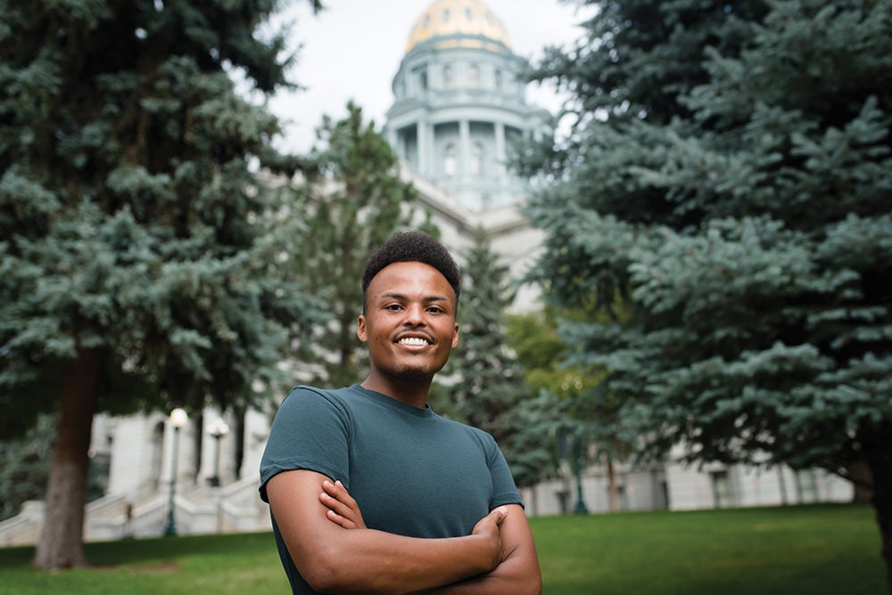 Eyob Abai smiles while standing outside the Colorado State Capitol.