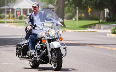 Erick rides his motorcycle through a small town as he arrives for a rural entrepreneurship workshop.