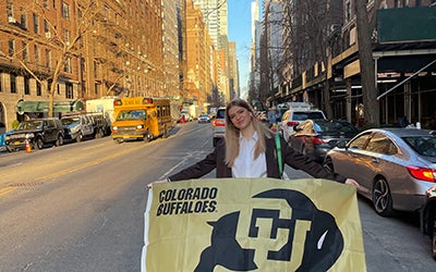 Lily Combs holding a Buffs flag on the streets of New York.