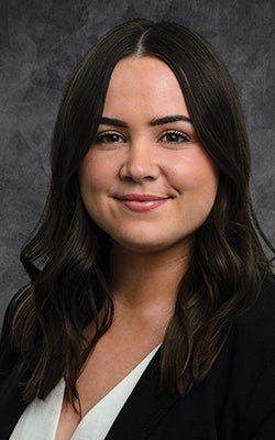 Portrait of Maeve against a gray backdrop.