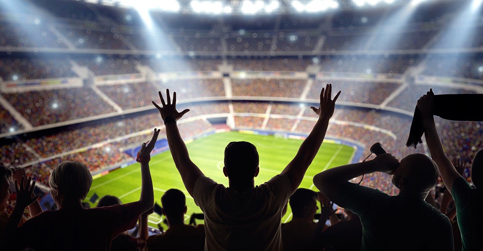 A football stadium full of fans celebrating a touchdown.