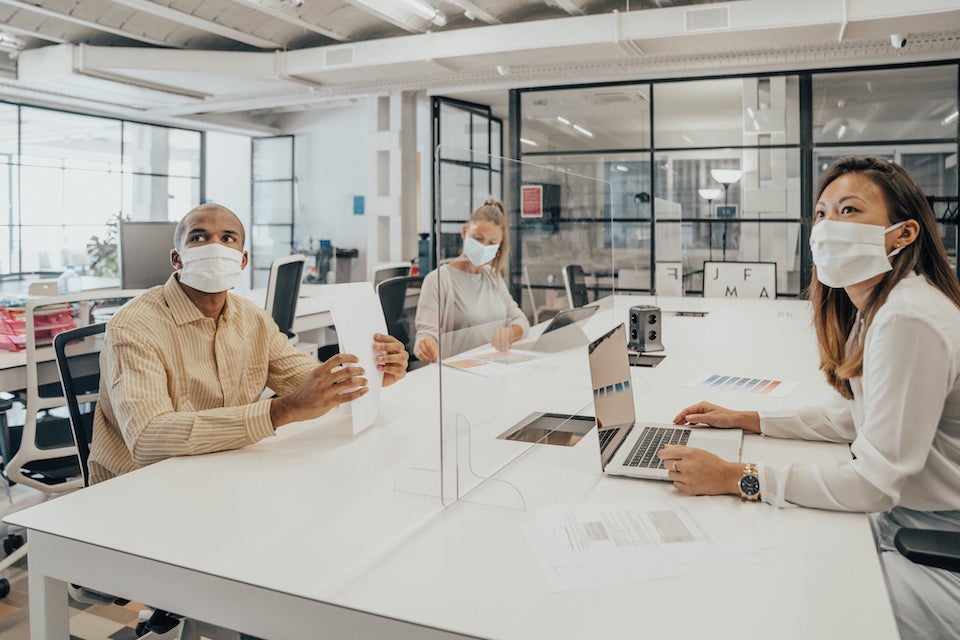 Business meeting with masked participants