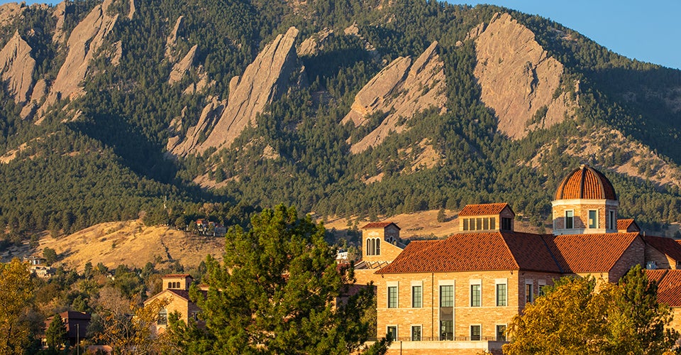 Koelbel building at sunrise.  The Flatirons mountains are visible in the background.