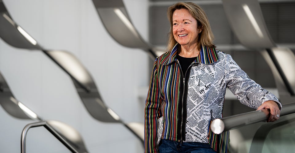 Libby Duane leans on a stairwell in a conference center.