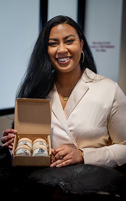 Laura Moore seated at a table with a box of her Silk By Laura products 