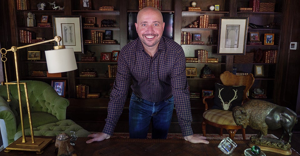 Ryan McMunn in his home office, which is full of artifacts from his travels abroad.
