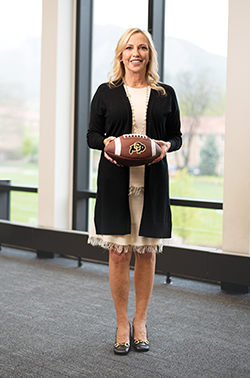 Jay Perry poses holding a football.