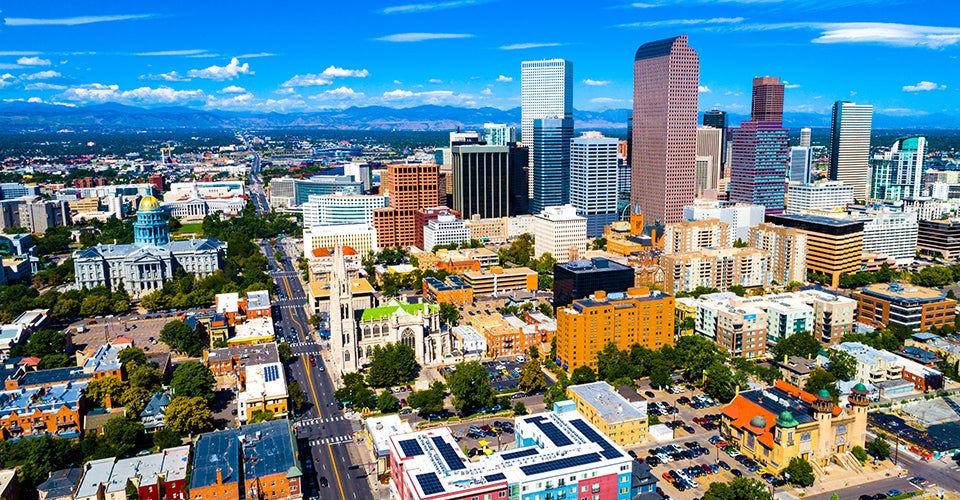 The Denver skyline on a clear day, with the Rockies visible in the background.