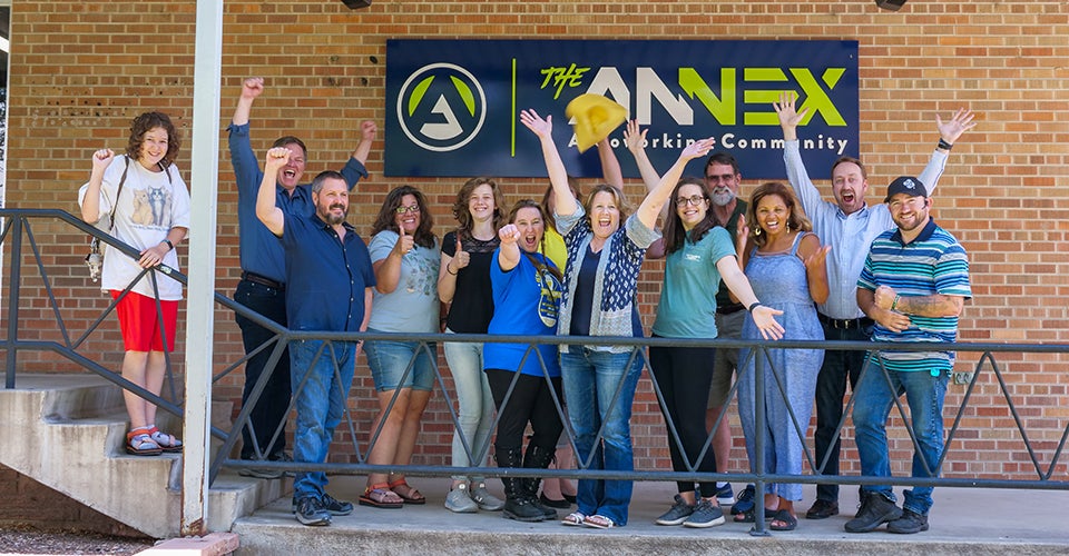 A group of entrepreneurs celebrating outside after completing the course.
