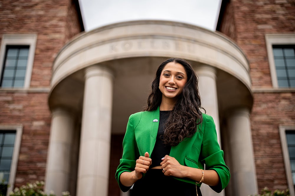 Trisha Tyagi smiles at the camera while posing on campus.