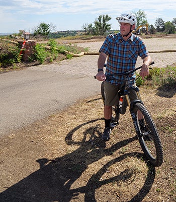 Jeff York on his bike.  The remains of a burnt sub-development can be seen in the background. 