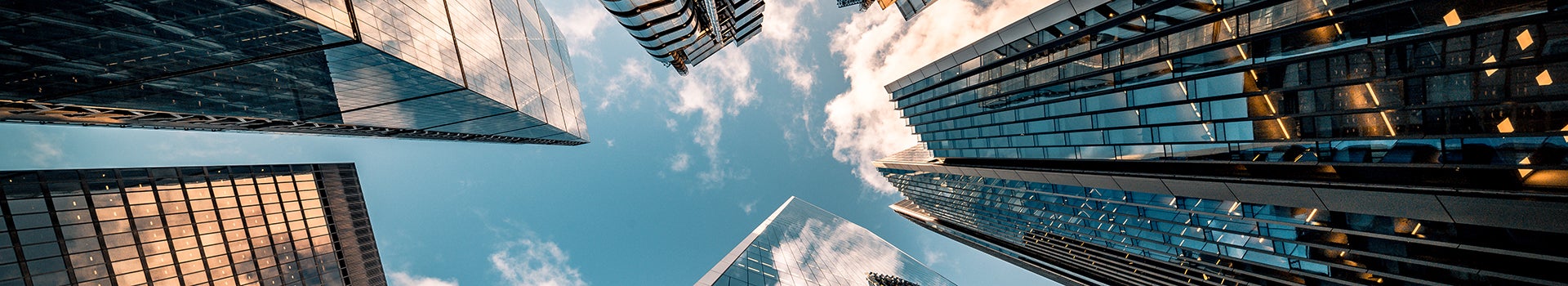 Looking up at the sky with several high-rise buildings looming overhead.