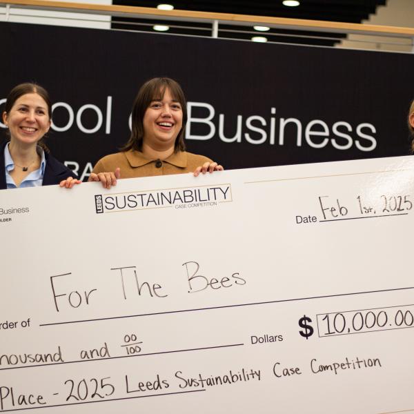 Winners Smiling and Holding Up Huge Check