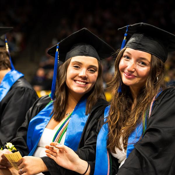 Graduates smile during the ceremony