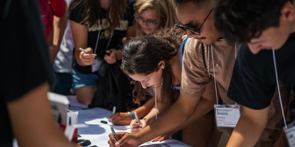 New students sign the welcome banner at Leeds Launch.
