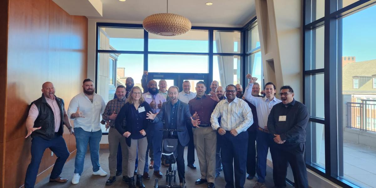 Executive Director Erick Mueller standing with veterans from the 2023 Veterans in Entrepreneurship Program