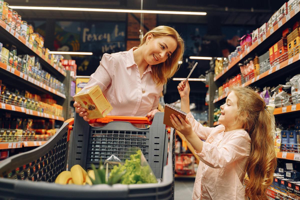 Image of Mother helping Daughter Pick out food at the grocery store