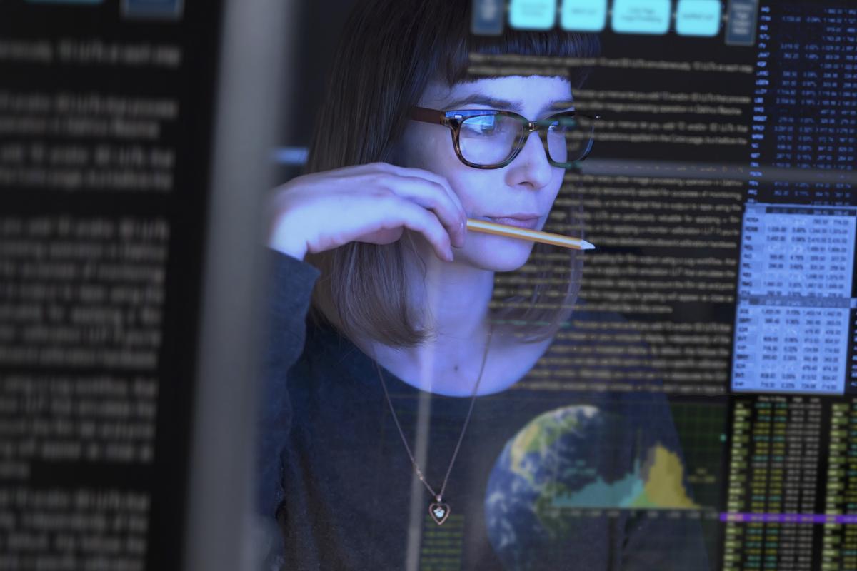 Image of woman looking at code on a screen