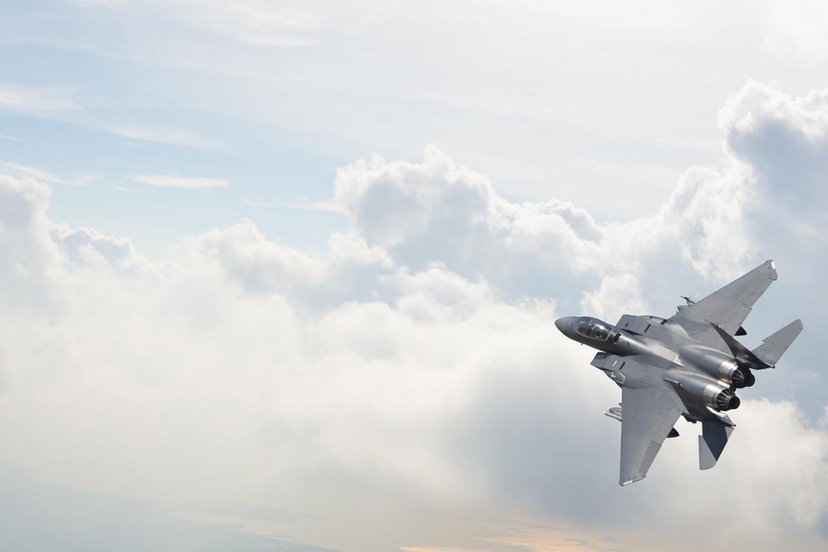 A fighter jet alone against a clear sky.