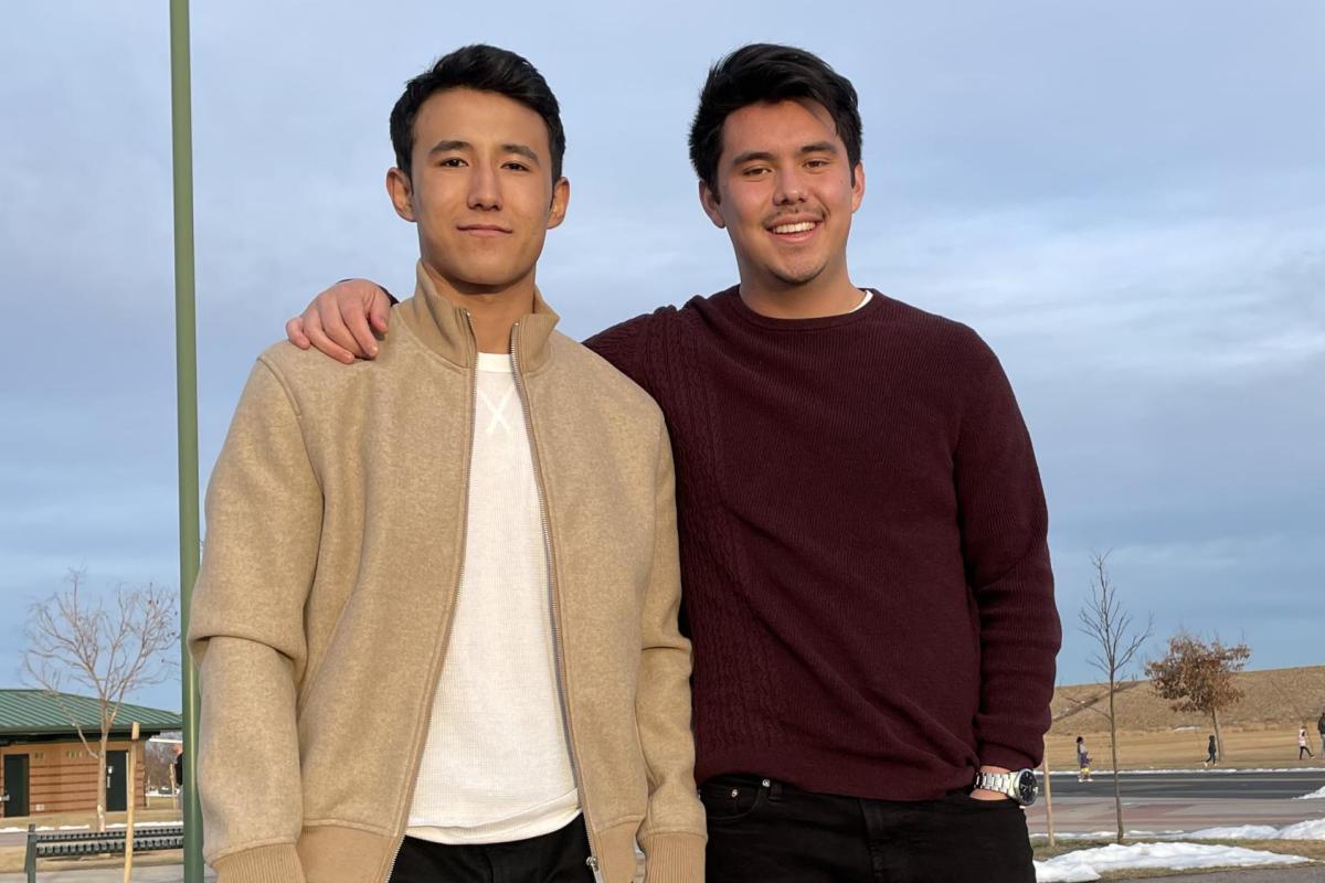 Kai and Sam pose for a group photo on a basketball court.