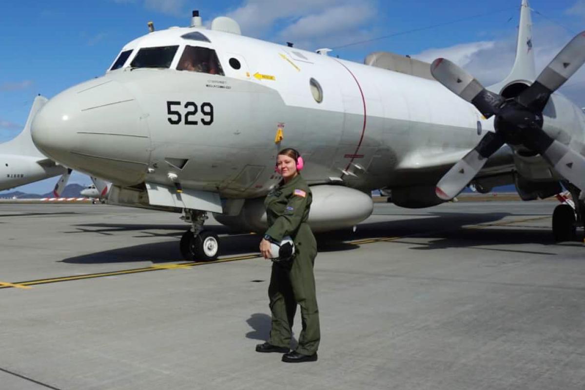Taylor poses outside a fighter jet.